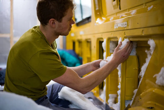 A man installing insulation in a van.