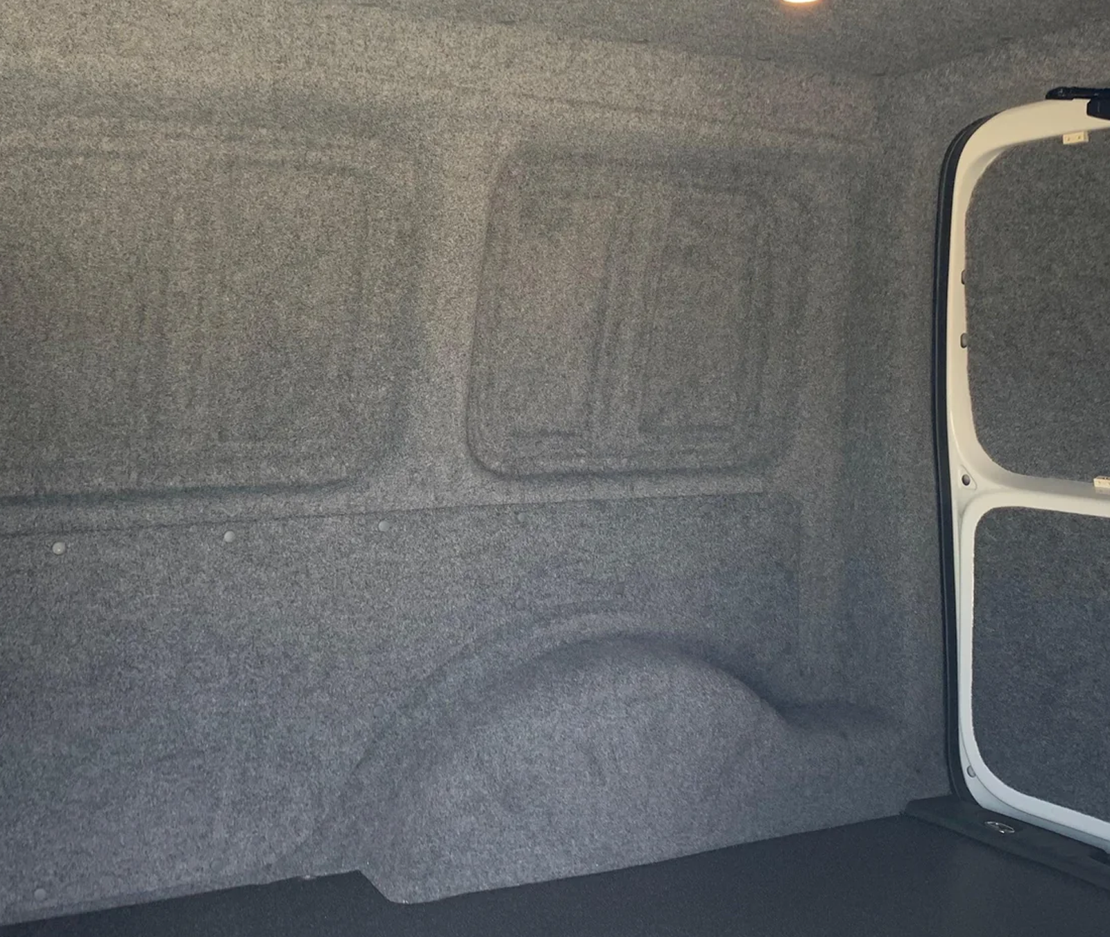 Grey carpet lining in the back of a van.